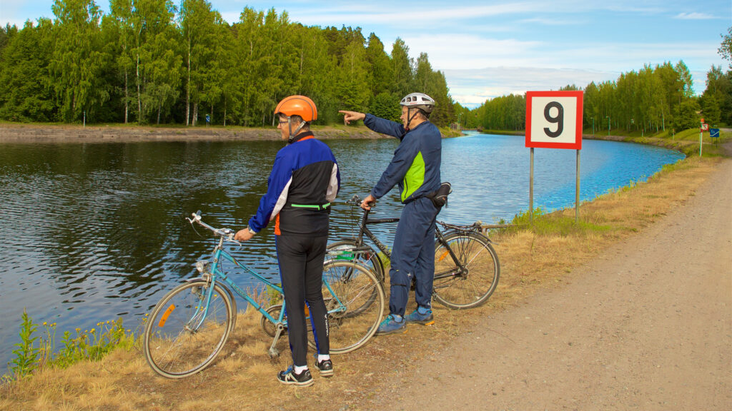 Kaksi pyöräilijää Saimaan kanavan varrella.
