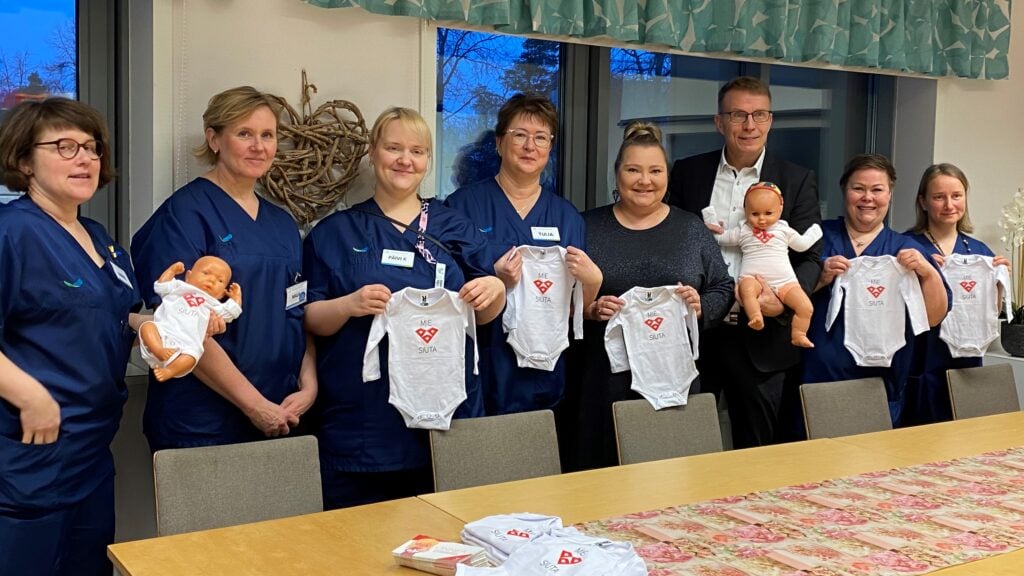 Etelä-Karjalan keskussairaalan henkilökunta ottaa vastaan vauva-asut maakuntahallituksen ja maakuntavaltuuston puheenjohtajilta.