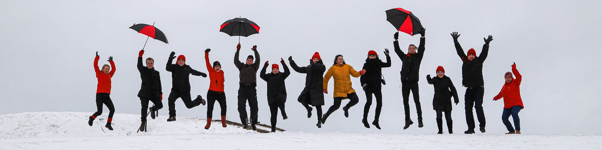 Etelä-Karjalan liiton henkilökuntaa hyppimässä rivissä Lappeenrannan Linnoituksen valleilla talvisessa maisemassa.