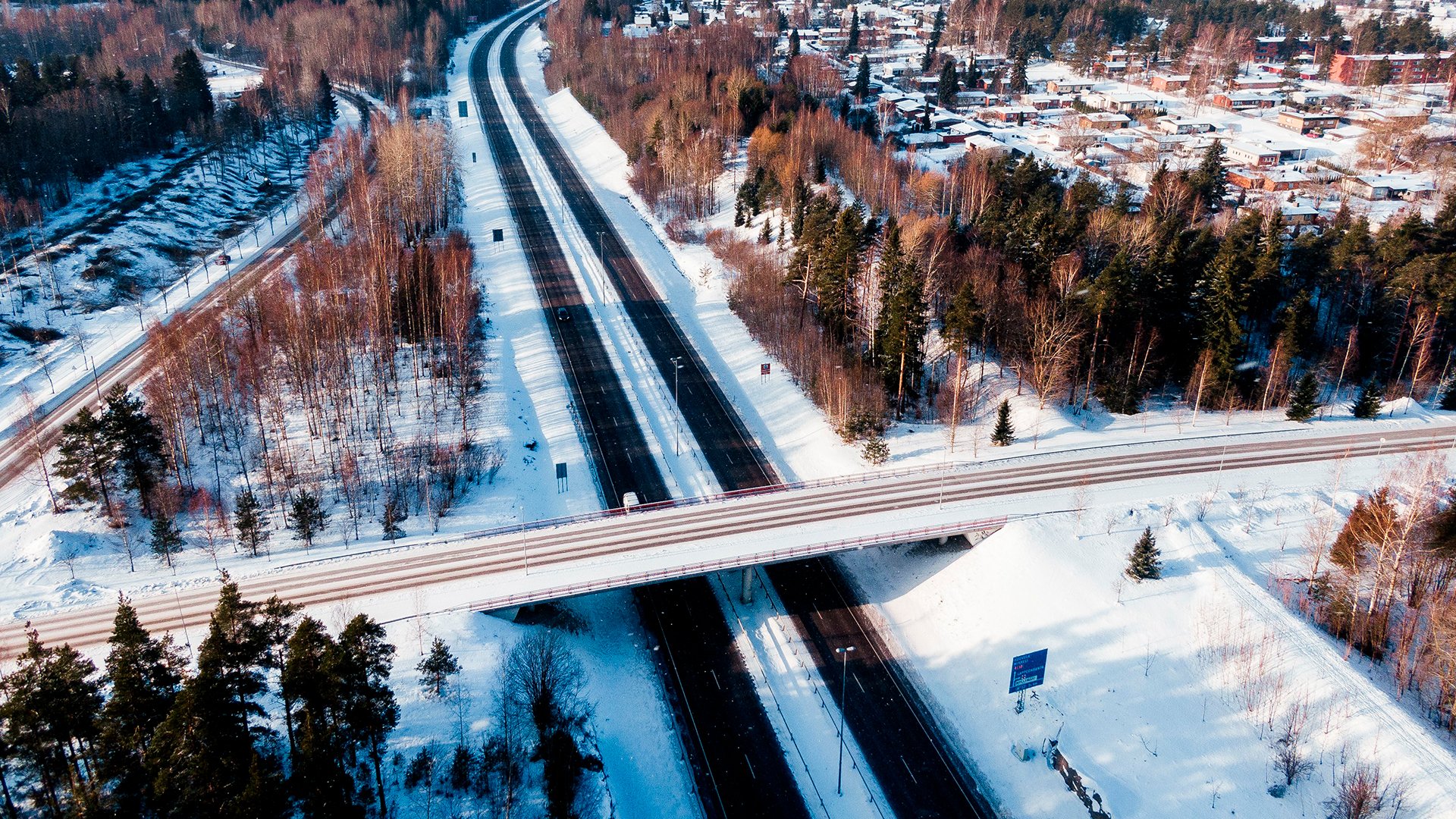 Talvinen ilmakuva, jossa näkyy teitä, junarataa ja taajama-asutusta.